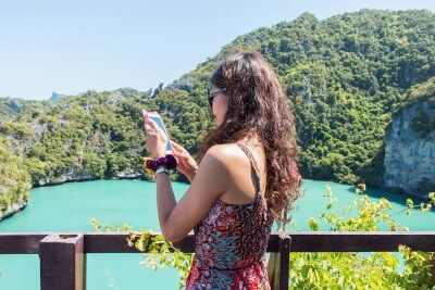 Femme avec smartphone au bord d'un lac